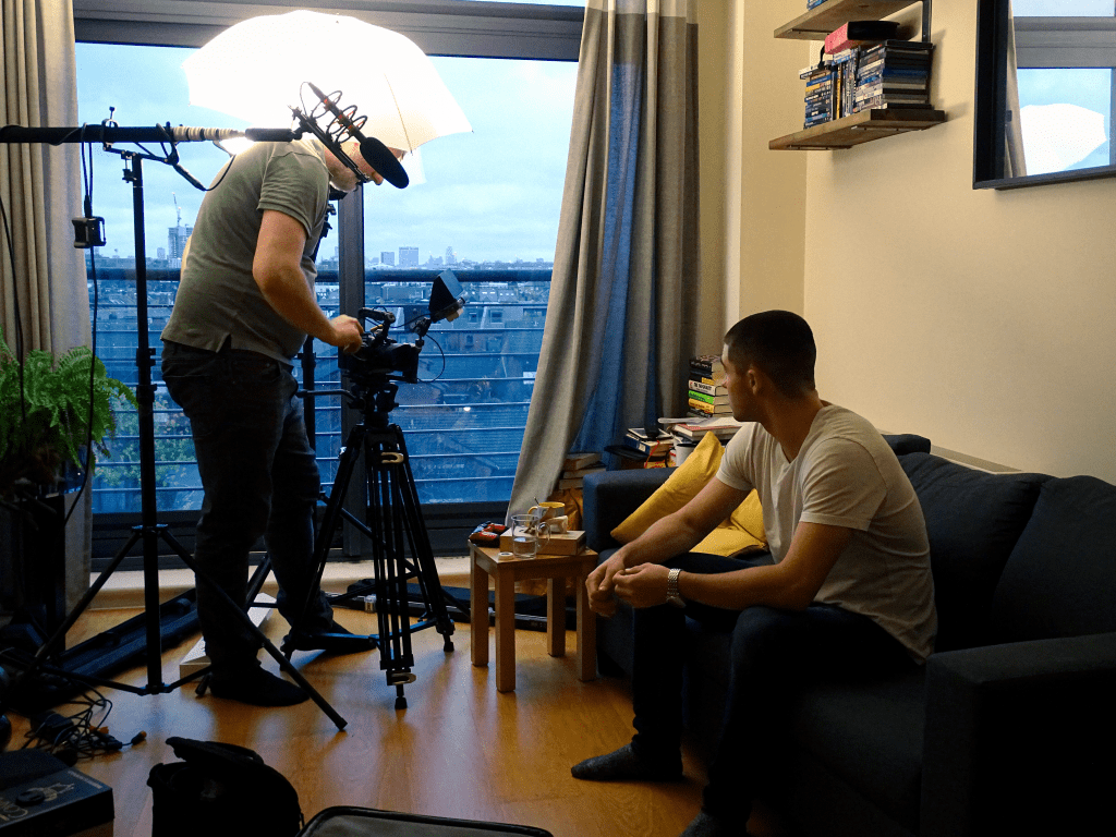 Actor waiting to film a take while director prepares camera.