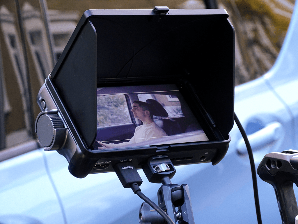 Monitor showing actor sitting in car.
